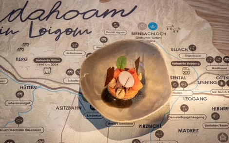 Ancient carrot Gourmet appetizer in ceramic bowl displayed on a Leogang region map